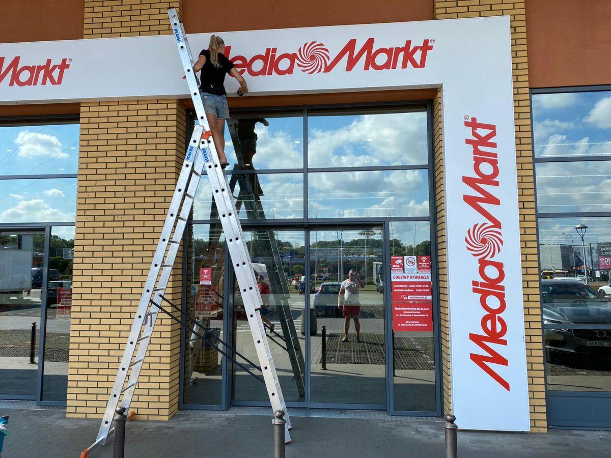 mycie szyldu nad wejsciem do media markt